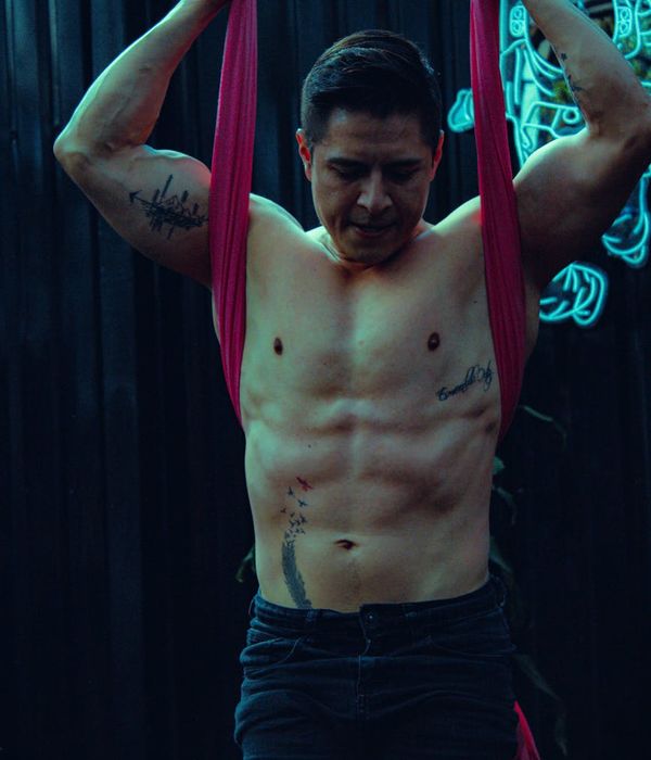 Man performing a controlled strength exercise in a dark, focused environment.